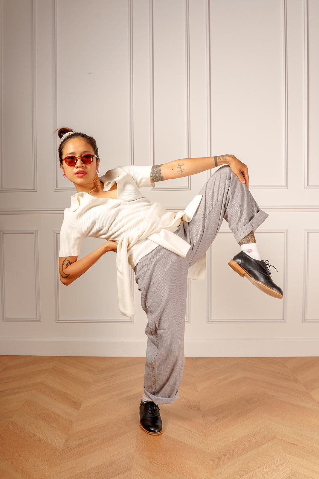 Danseuse de lindy hop en derbies noires, jambe levée sur un parquet